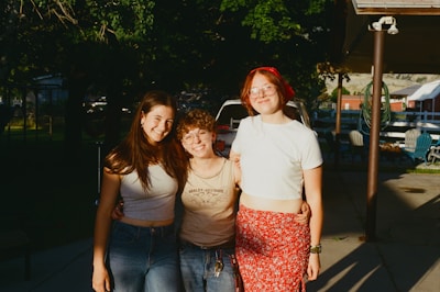Three smiling friends pose for a photo together.