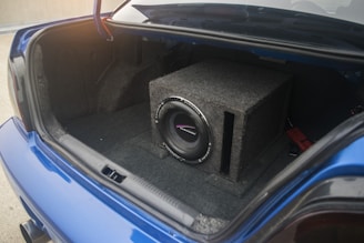 A car trunk contains a subwoofer system.