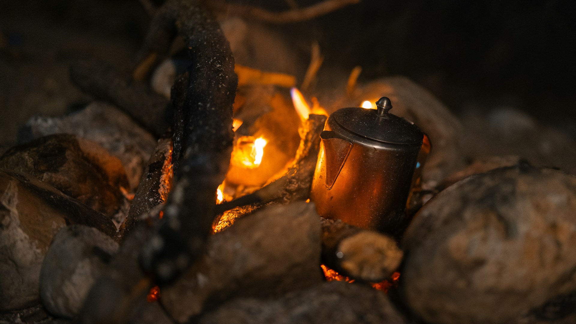 Campfire with a kettle cooking over the flames.