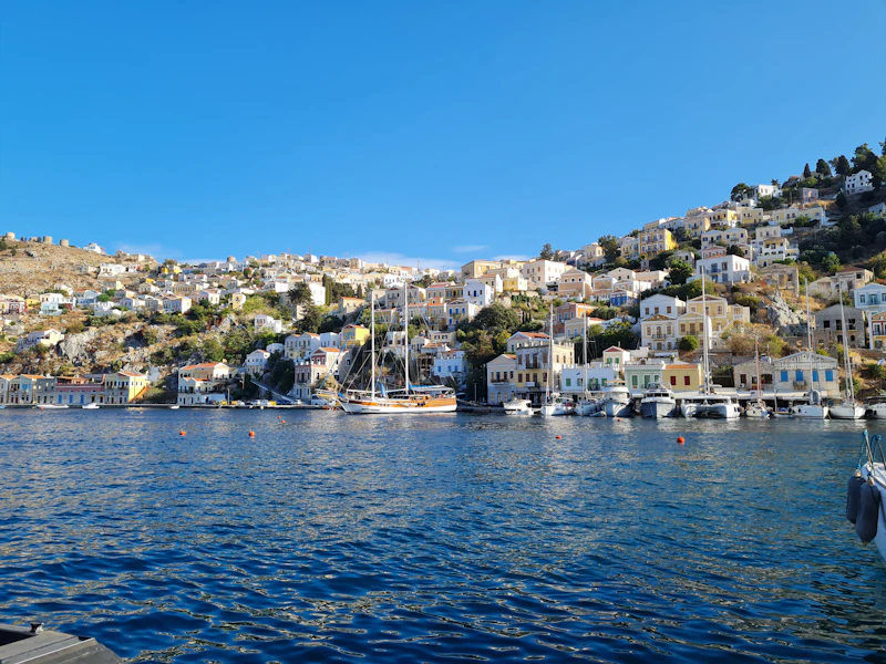Symi harbour, its houses stacked in pastel tiers above the water