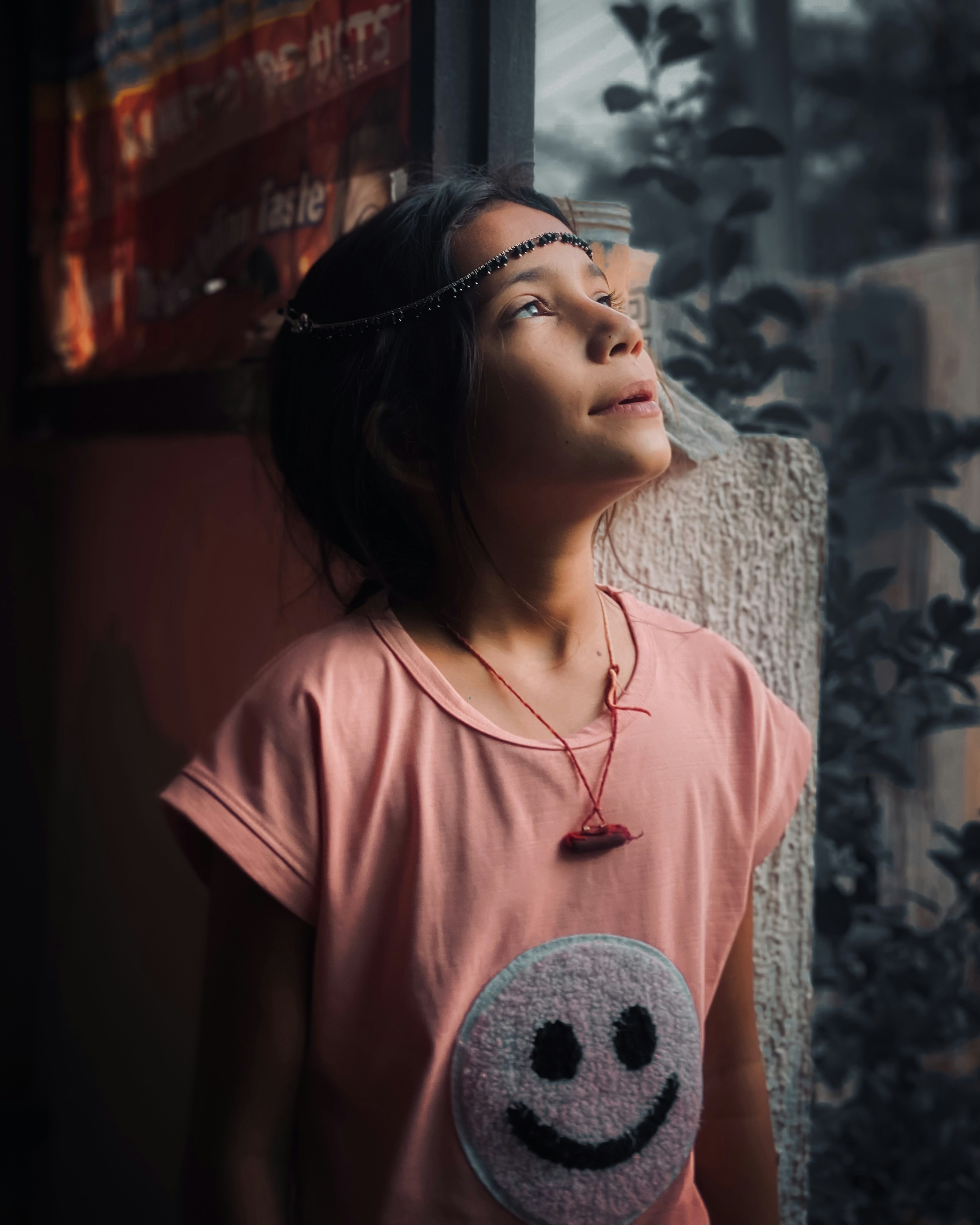 A girl gazes upwards, bathed in sunlight.