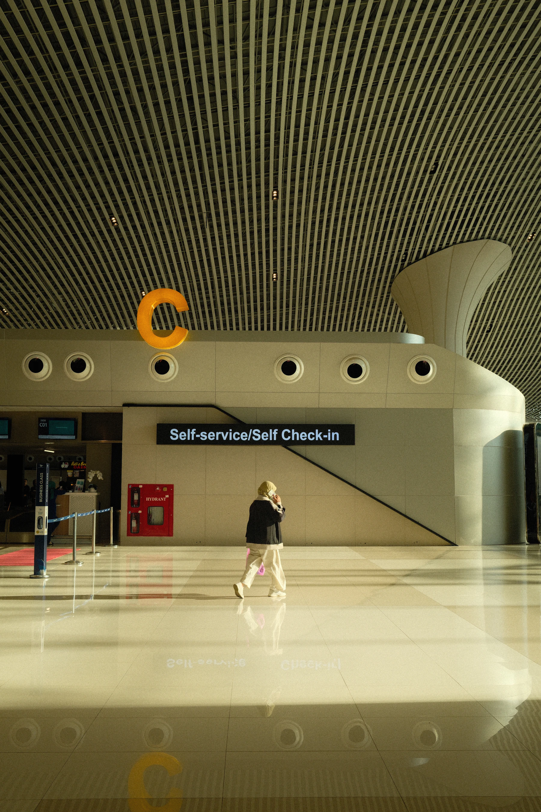 A traveller walking through a modern airport terminal