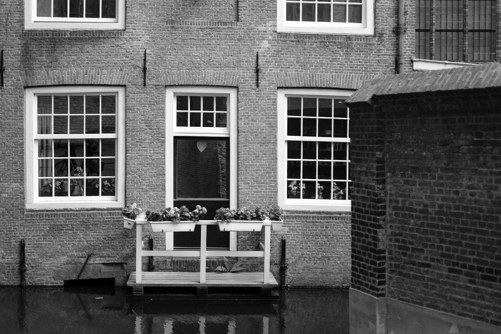 Standing water near the exterior wall of a house close to an electrical meter