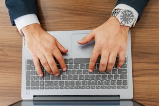 A person types on a laptop at a desk.