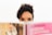 Woman gazes intently over a book's pages.