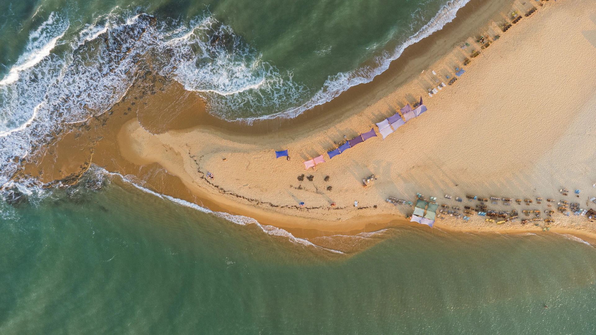 An aerial view shows a sandy beach peninsula.