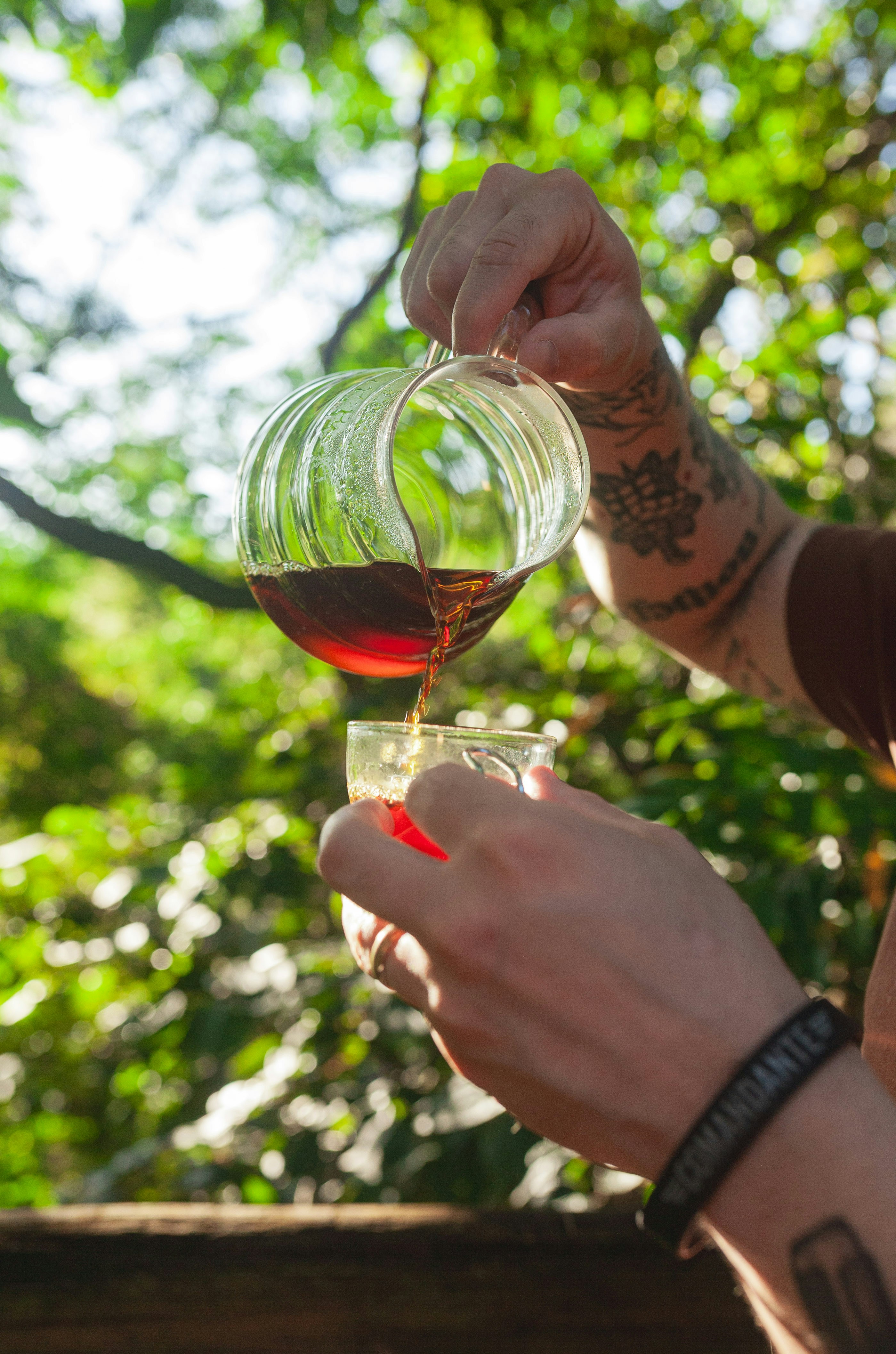 Someone is pouring tea from a glass pot.