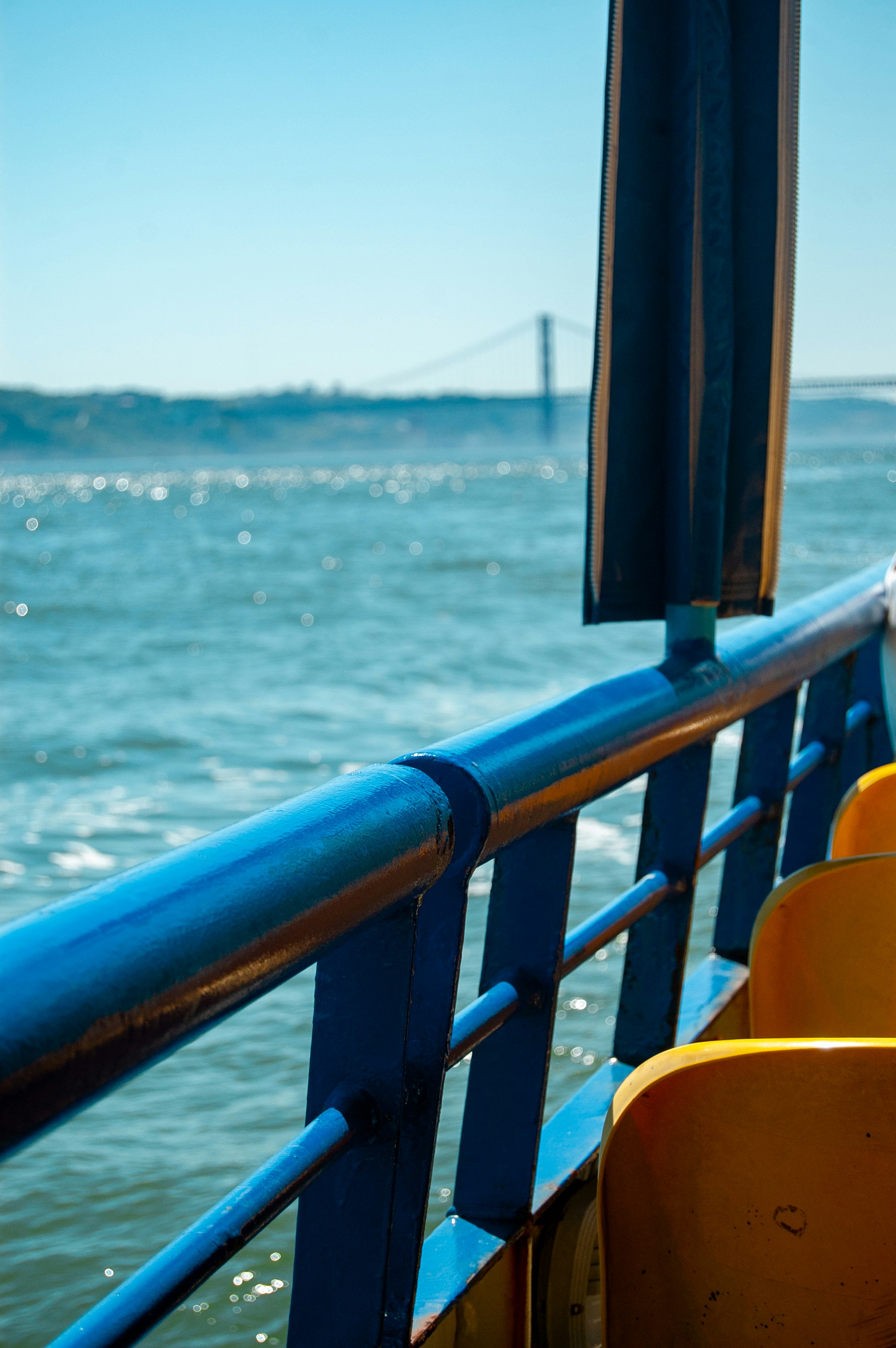 A boat travels past a bridge on a sunny day.