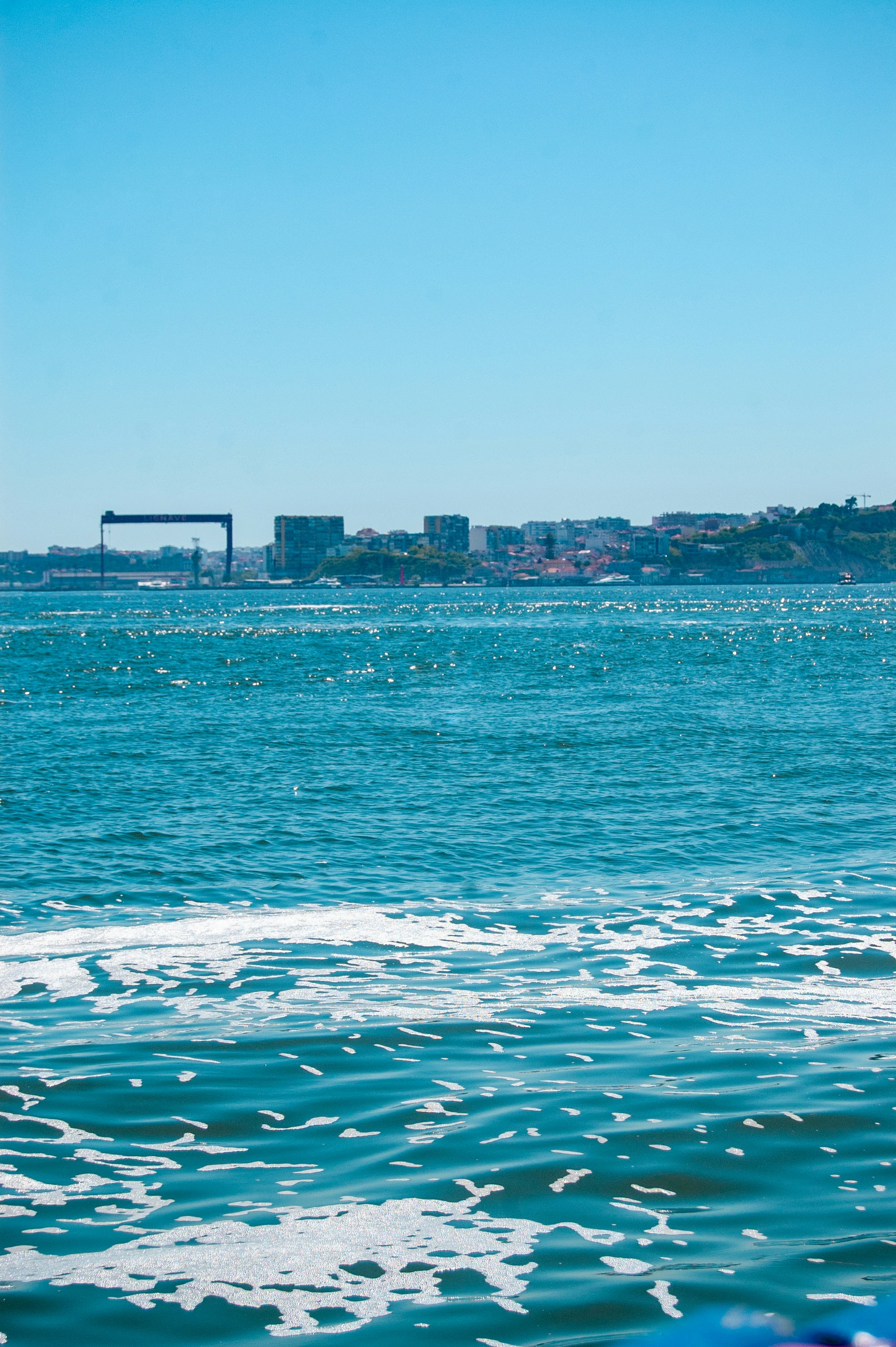 Blue ocean waters with a distant city skyline.
