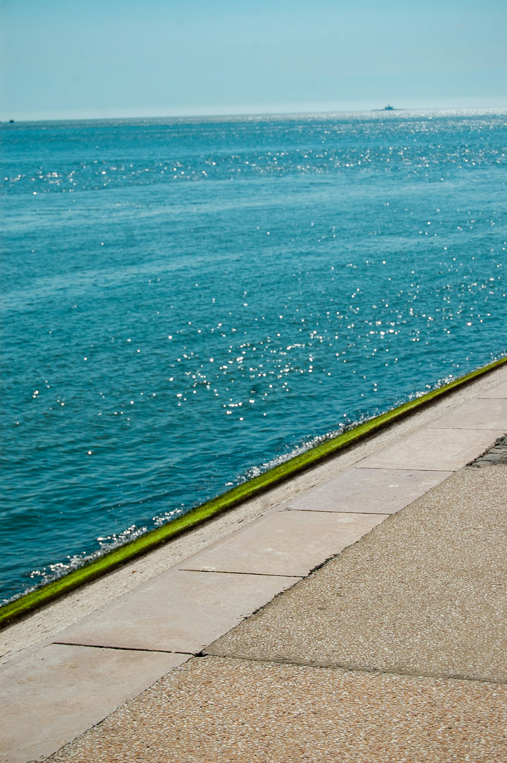 Ocean water meets a cement shoreline.