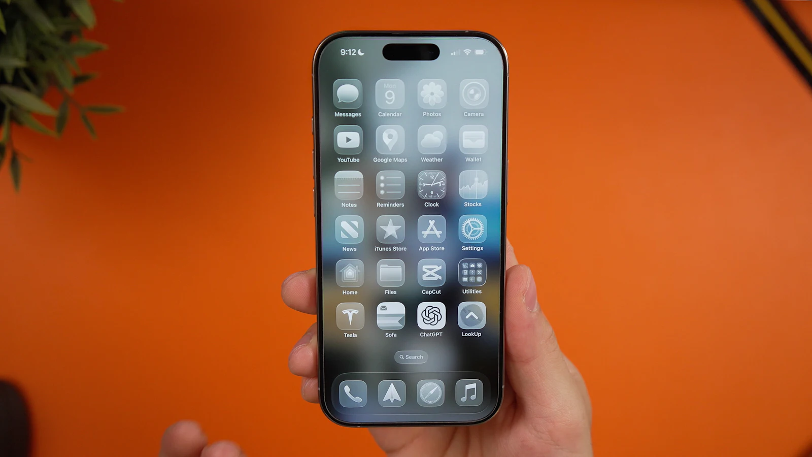 A person holding an iPhone showing its home screen of apps