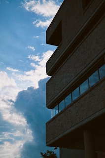 Brick building rises against a cloudy sky.