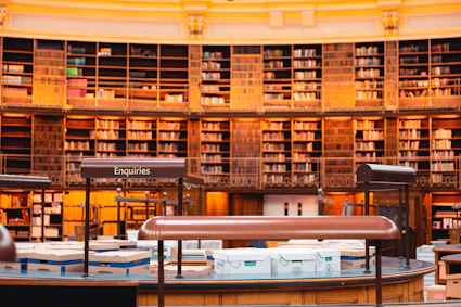 A grand library filled with books and tables.