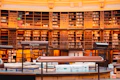 A grand library filled with books and tables.