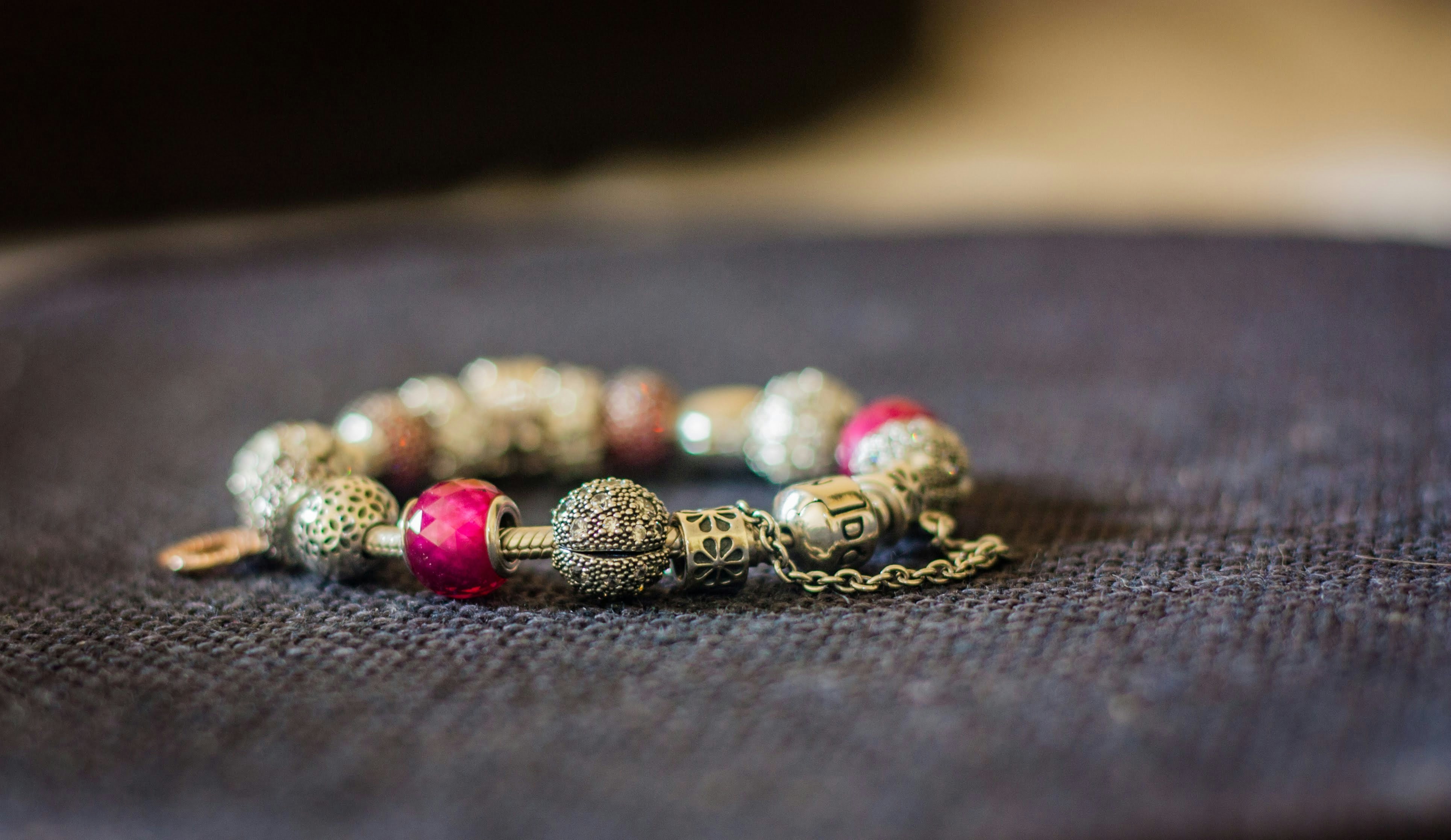 A bracelet with beads rests on a dark surface.