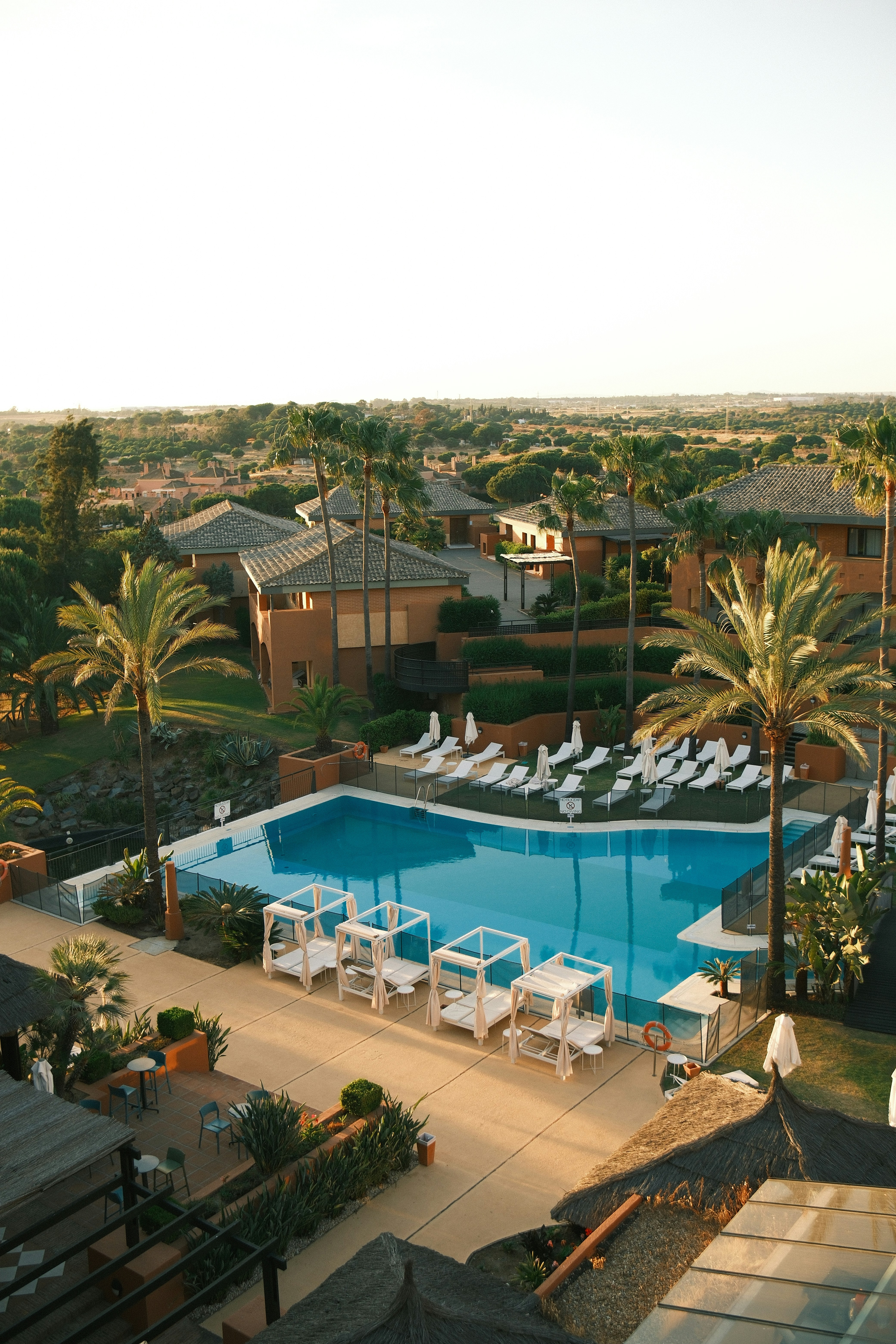 A luxurious pool with cabanas and a scenic view.