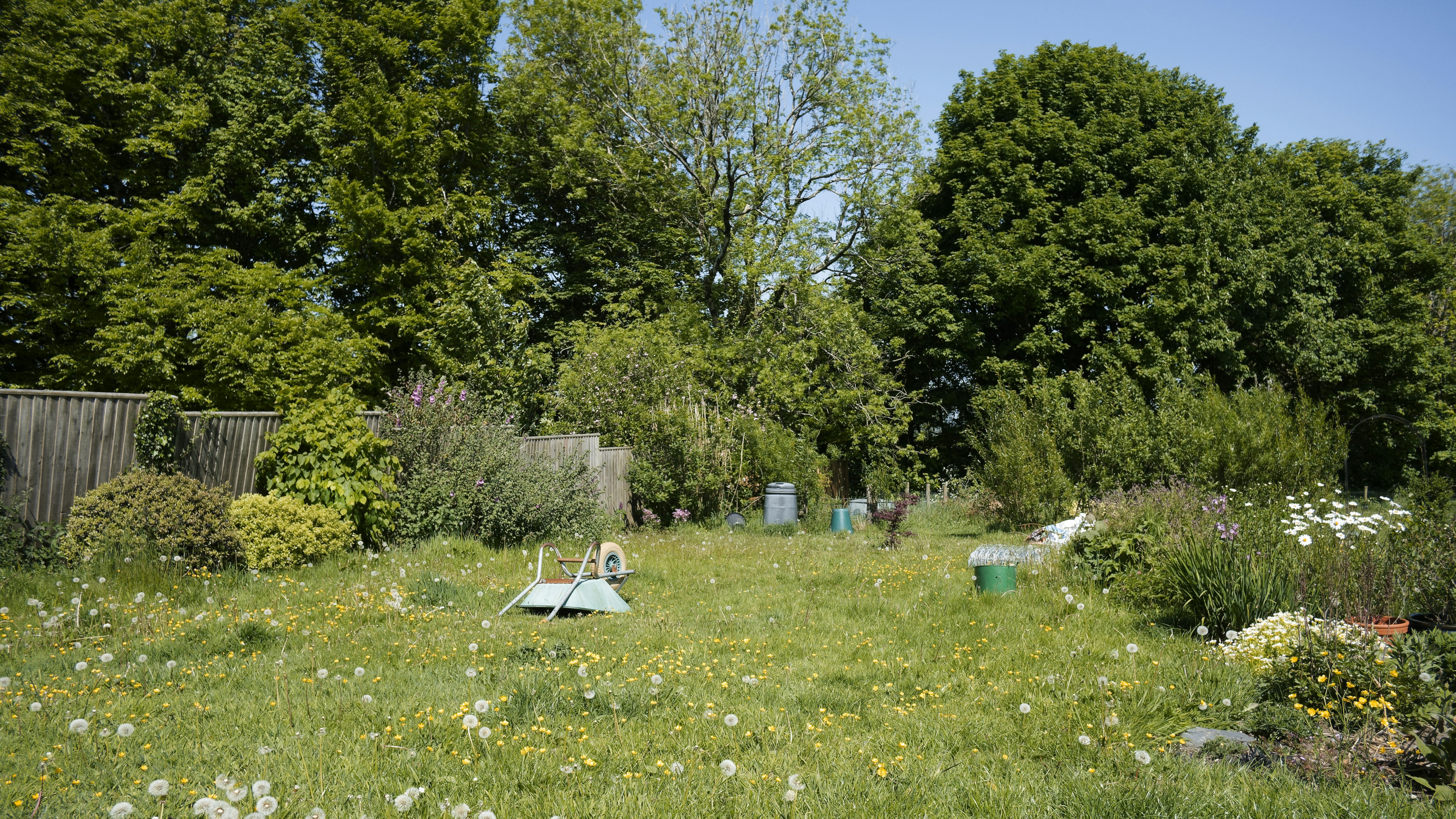 Landelijke tuin met weelderige beplanting en natuurlijke materialen.