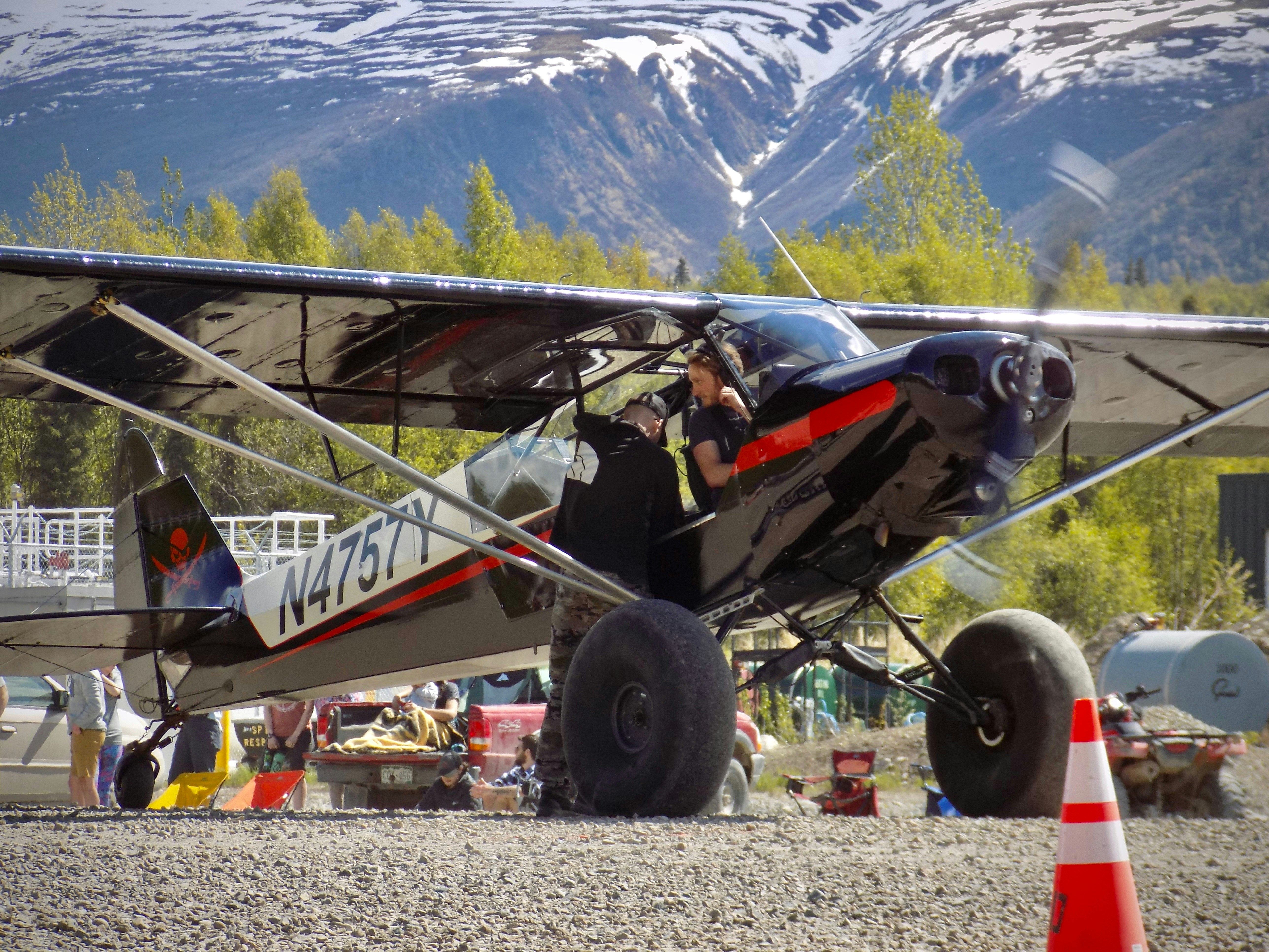 A small airplane is parked with mountains in the background.