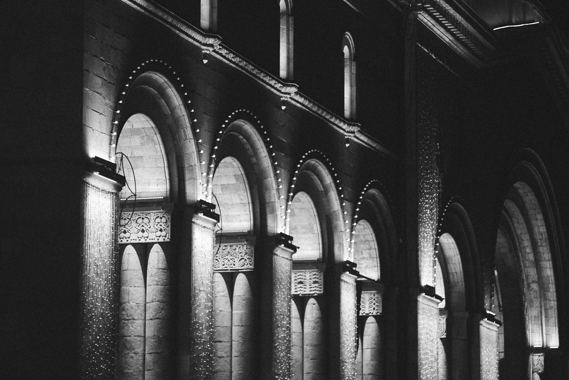 Arches are lit up in a dimly lit hallway.