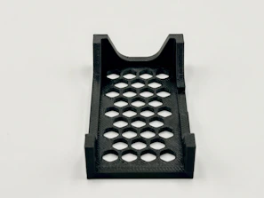 A black 3d-printed tray with hexagon cutouts.