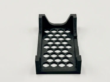 A black 3d-printed tray with hexagon cutouts.