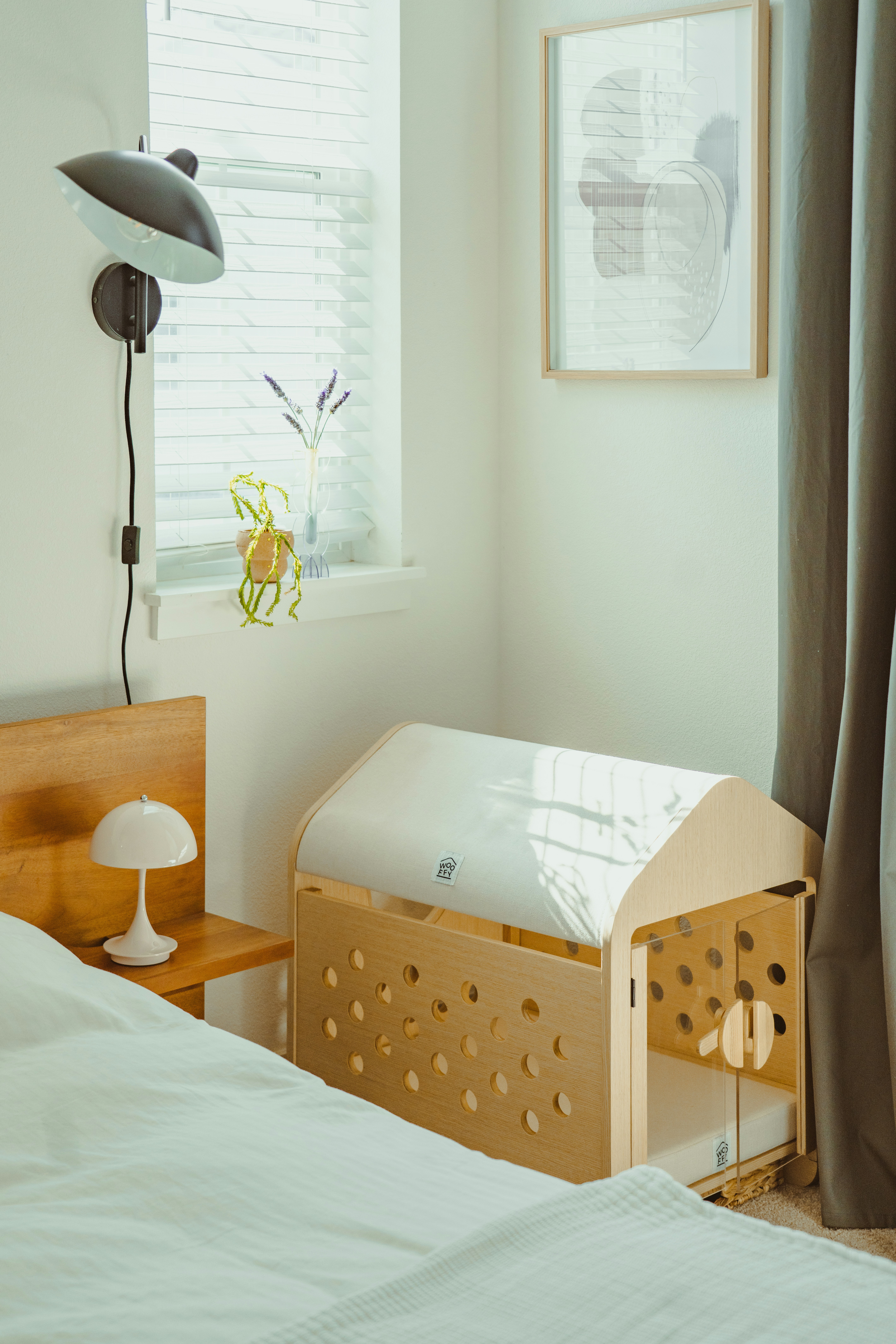 Holzbabybett neben einem Bett in einem Zimmer.