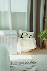 Striped storage ottoman with pillows and blanket.
