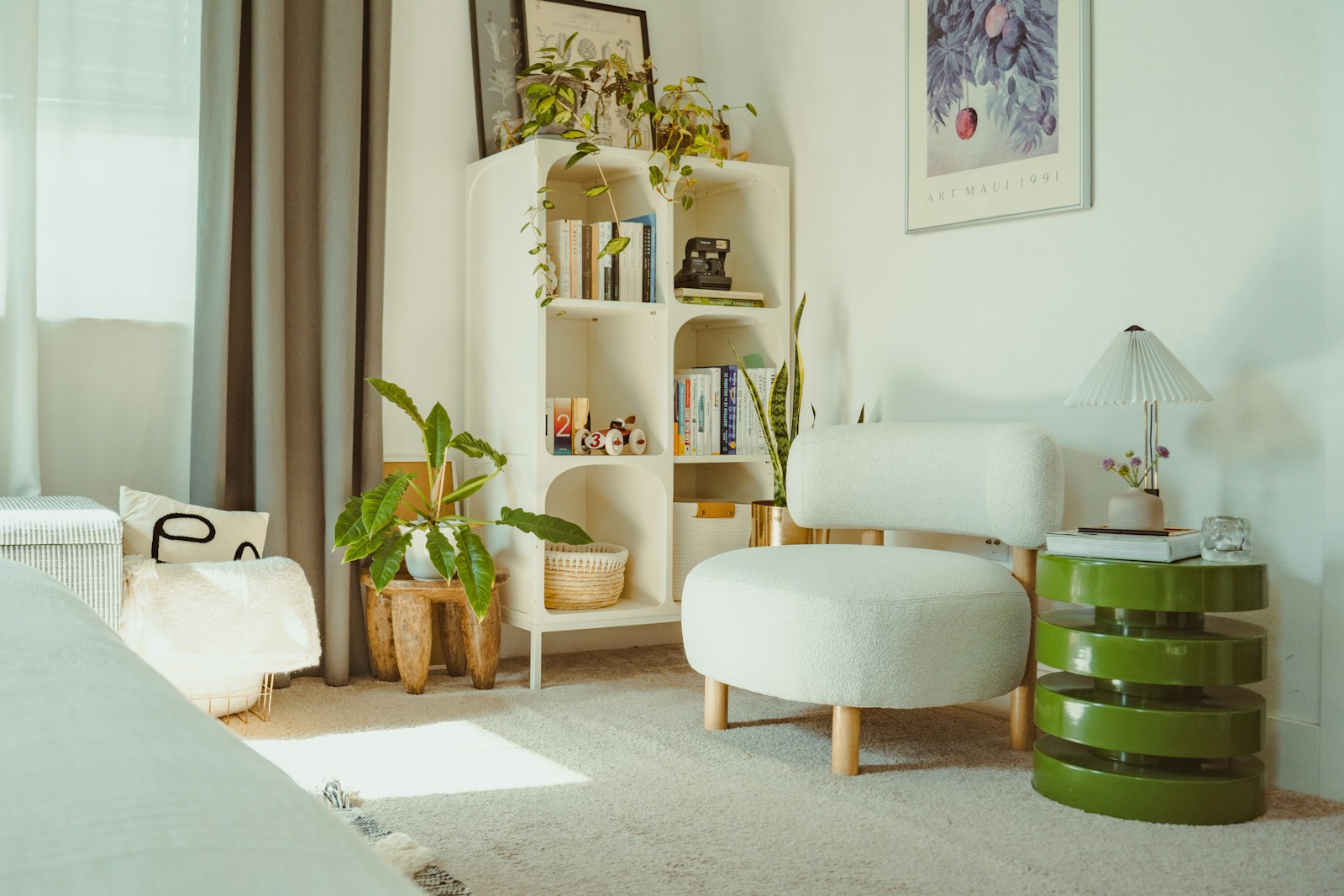 bright small apartment corner with plants, bookshelf and boucle chair