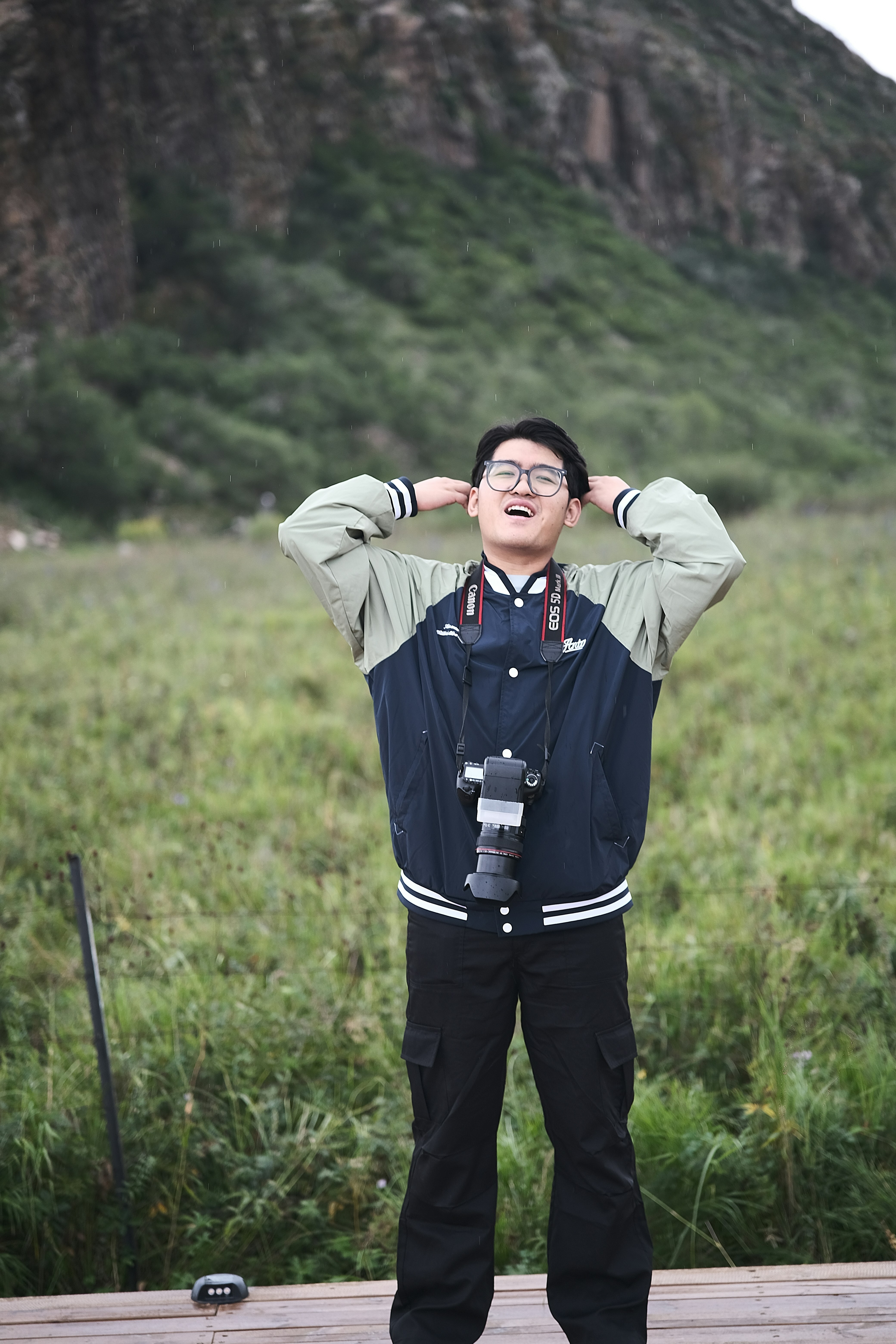 Fotógrafo feliz posa frente a una montaña escénica.