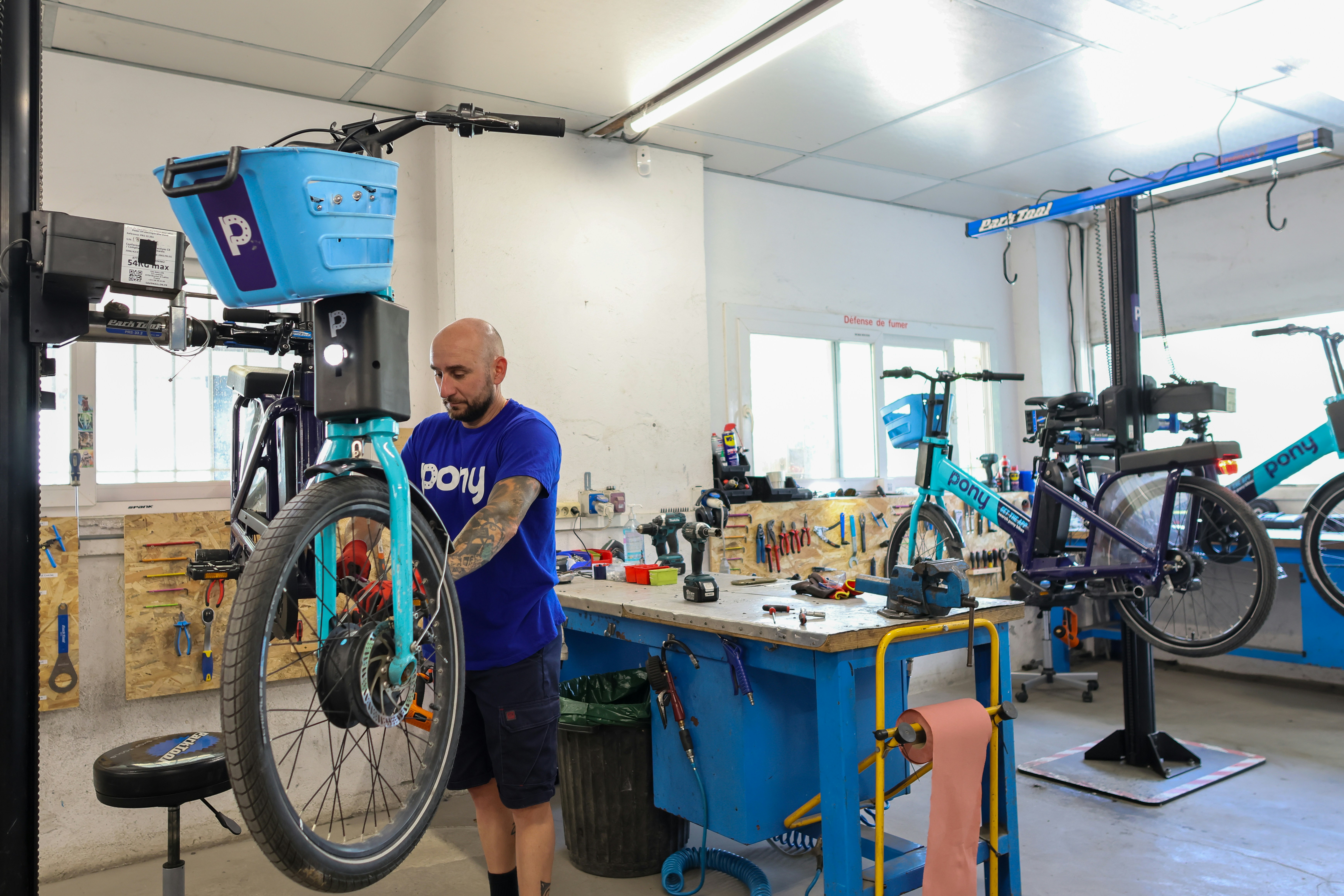 Mechanic repairs a bicycle in a workshop.