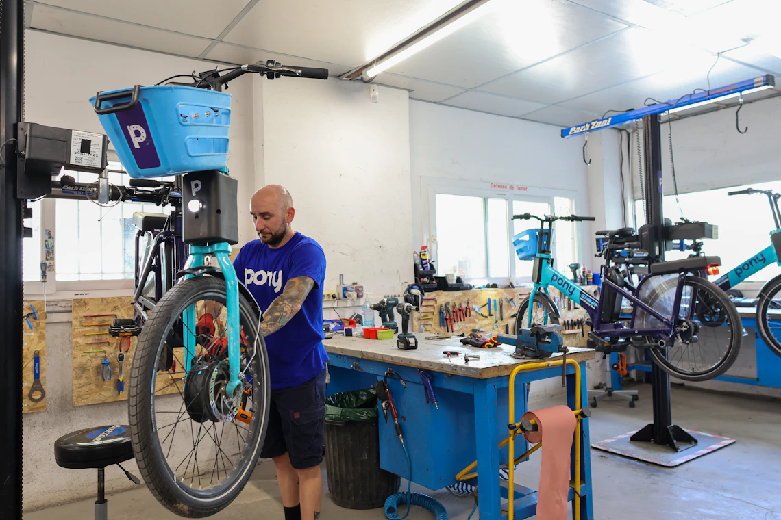 Mechanic repairing a bicycle inside a professional workshop