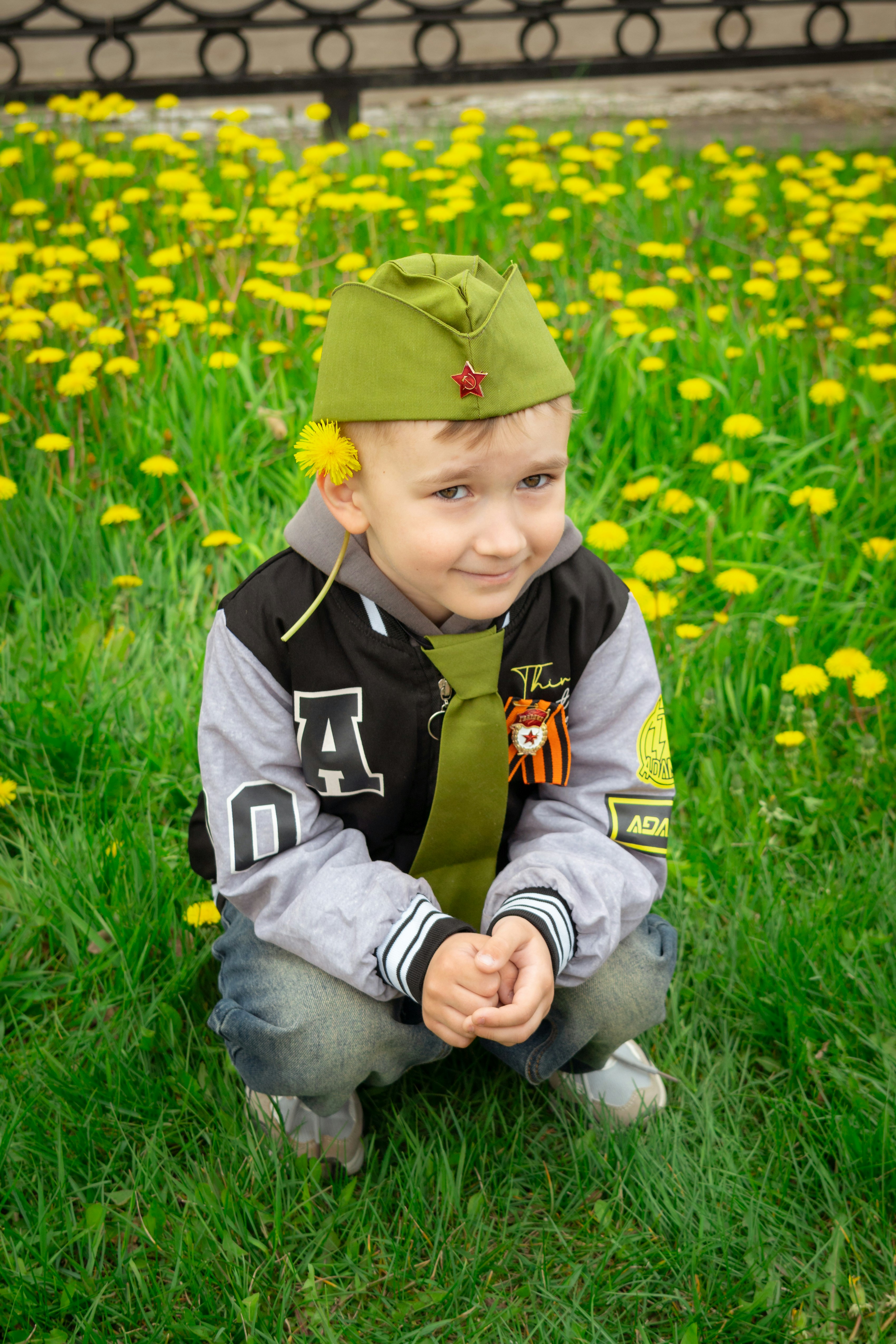 A young boy is smiling in a field of flowers.