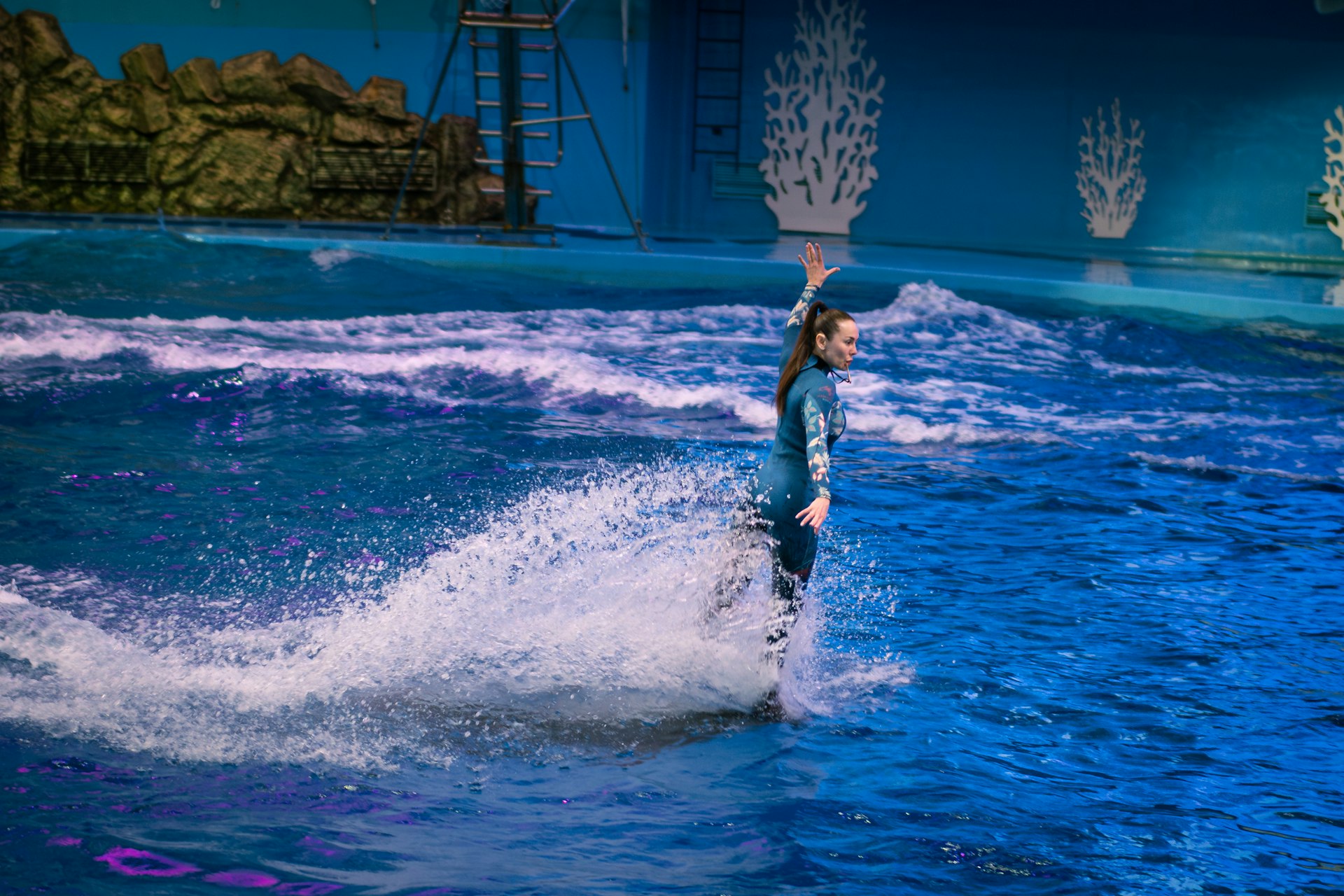A woman performs a water stunt in a pool.