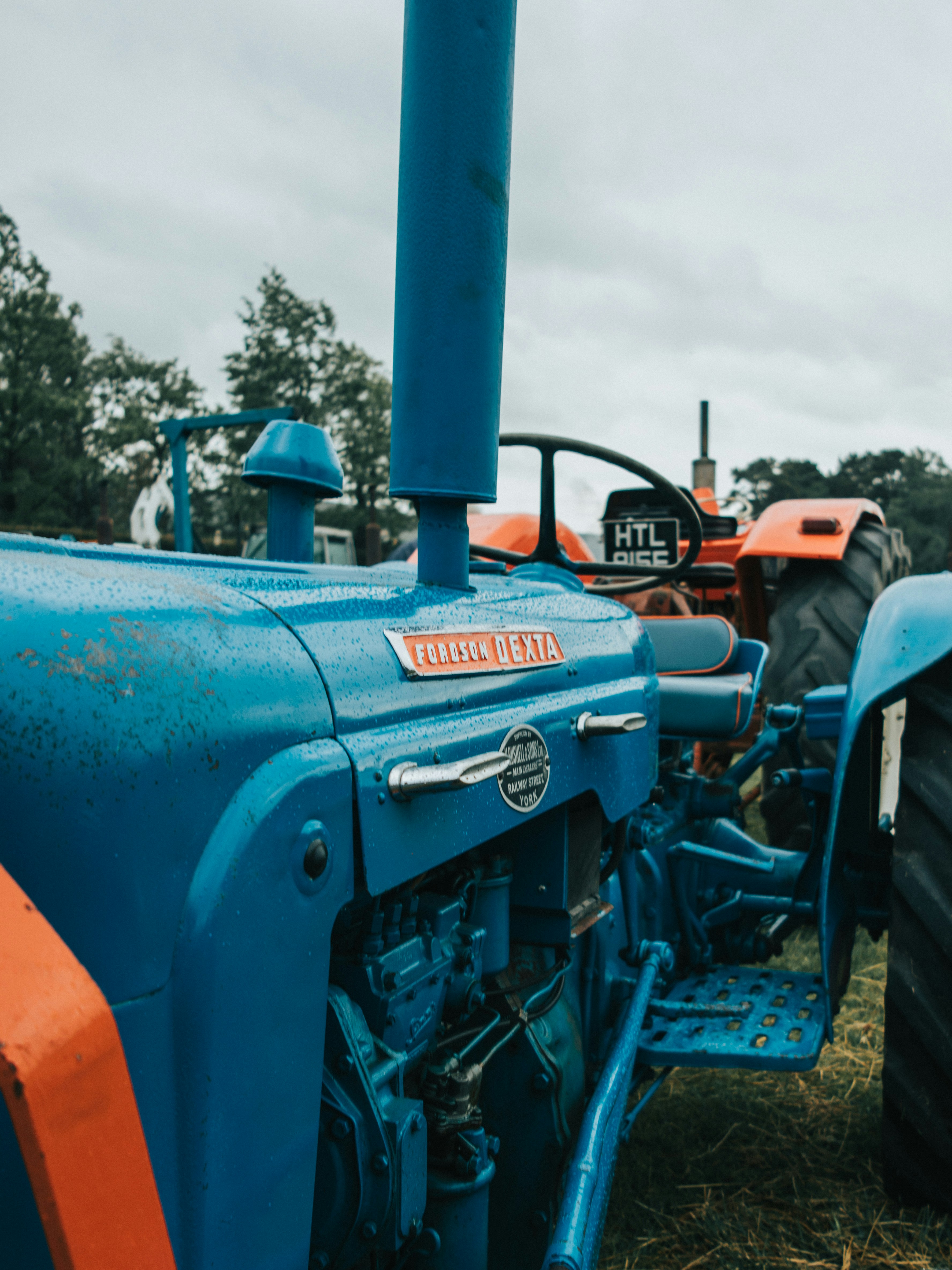 A blue vintage tractor parked in a field.