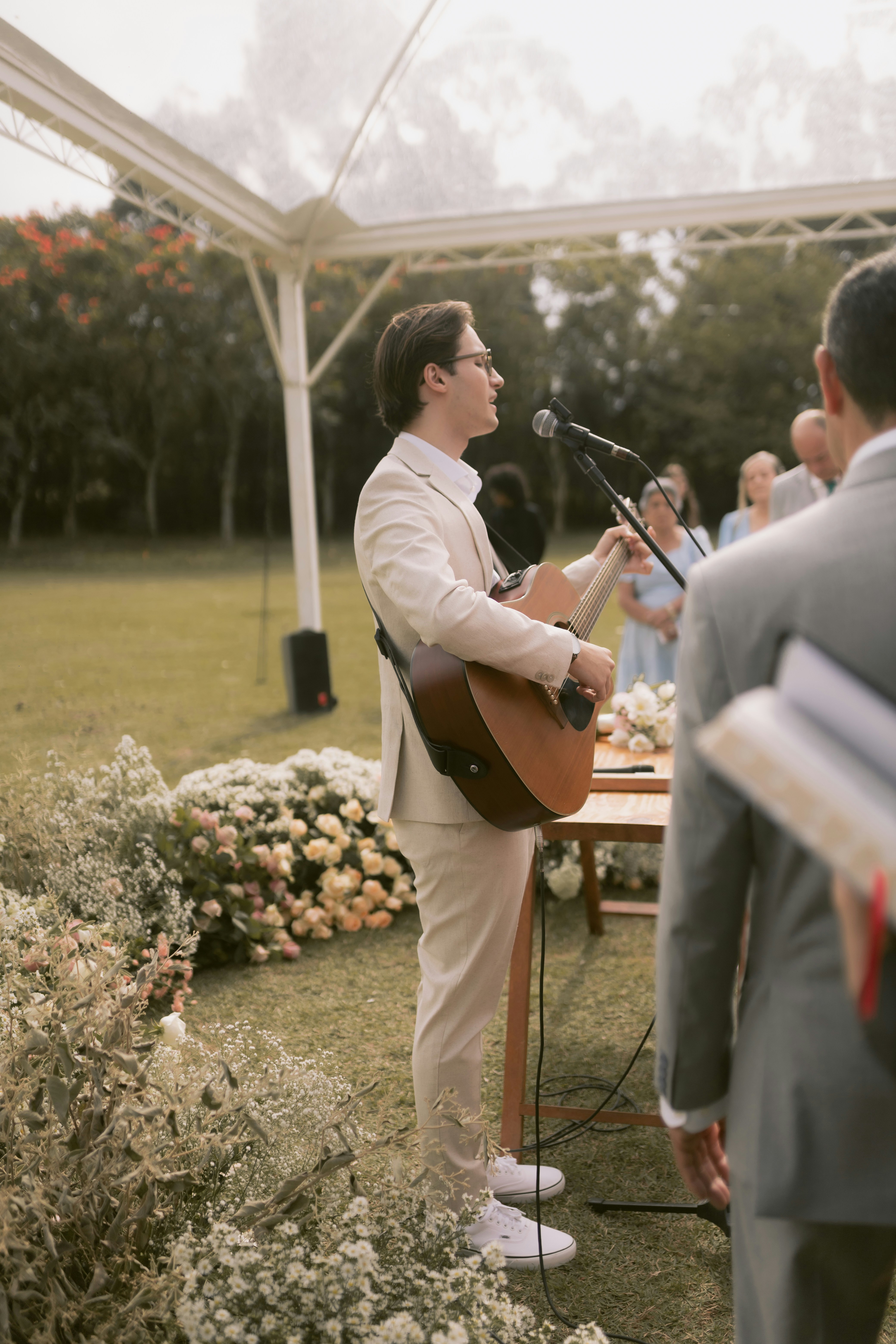 A musician performs at an outdoor wedding ceremony.