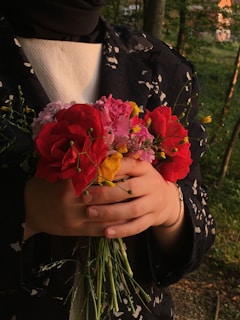 Person holding a beautiful bouquet of flowers.