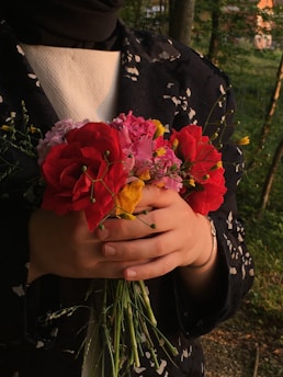 Person holding a beautiful bouquet of flowers.