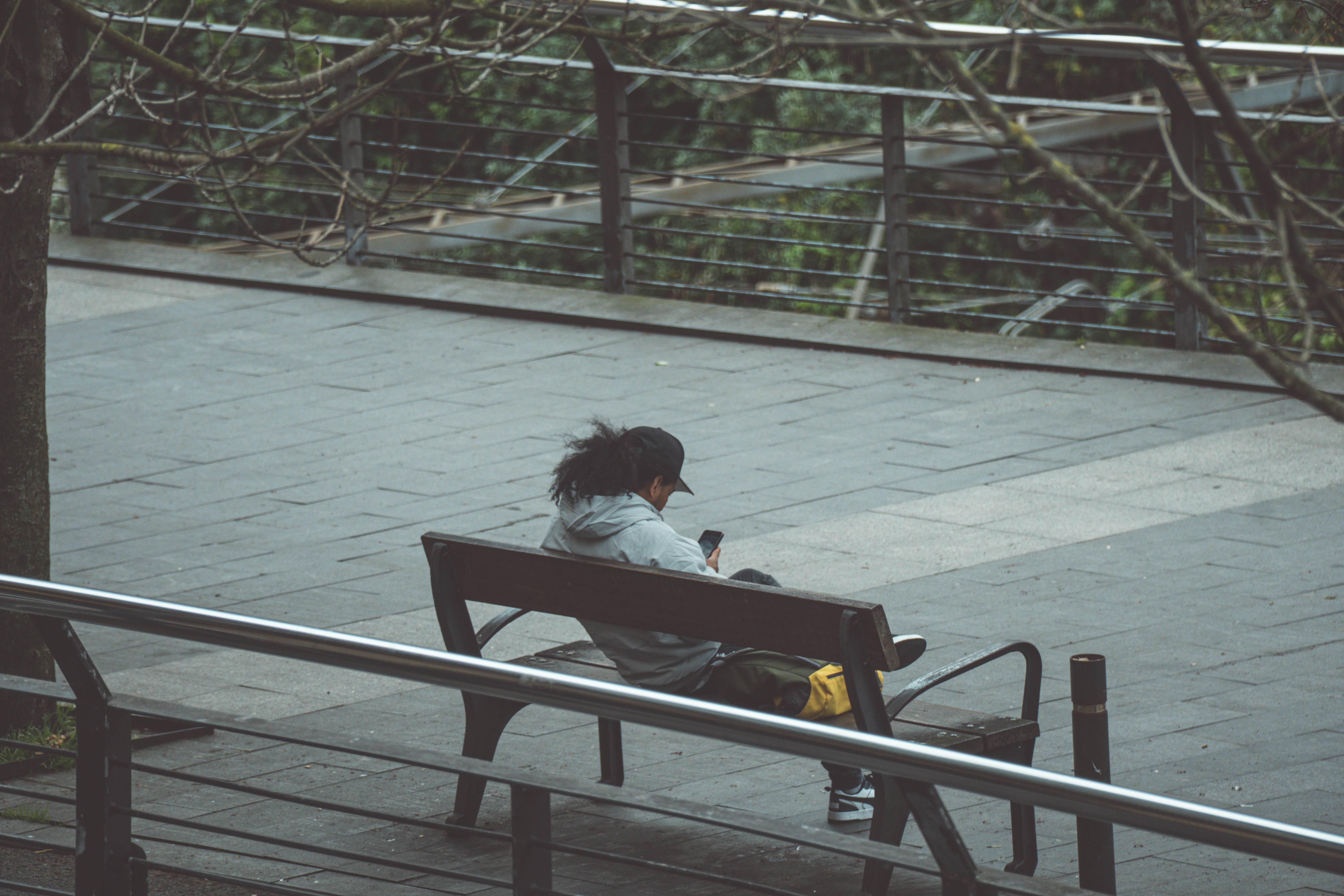 A person sits alone on a bench outdoors.