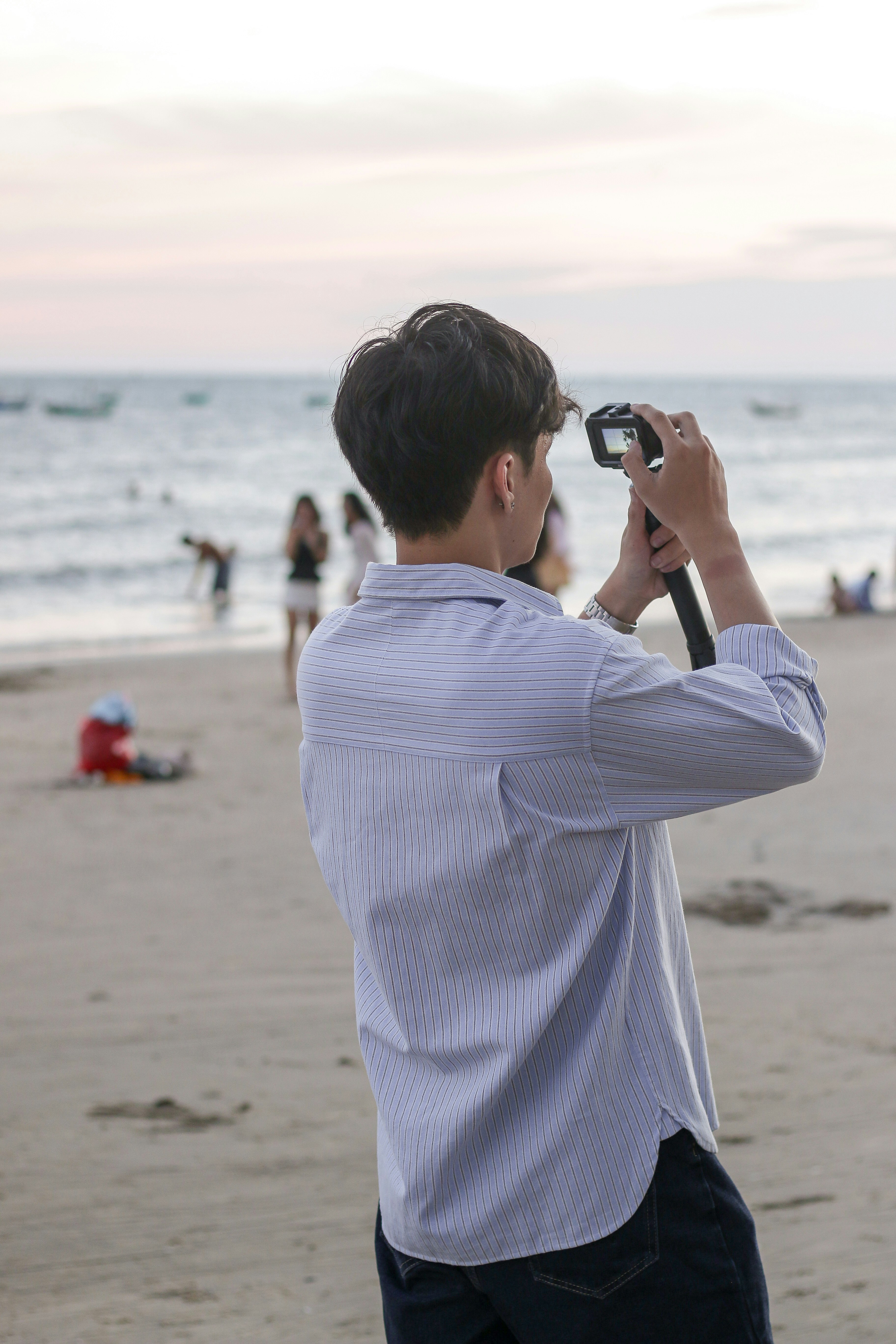 A person photographs the beach with a camera.