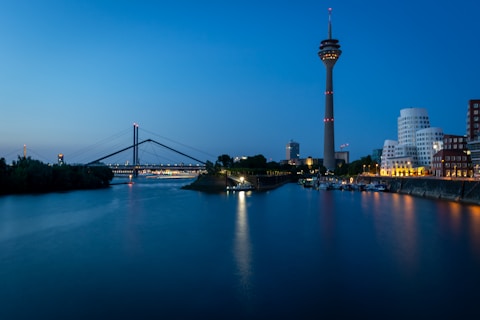 Dusseldorf skyline at night with bridge and tower.
