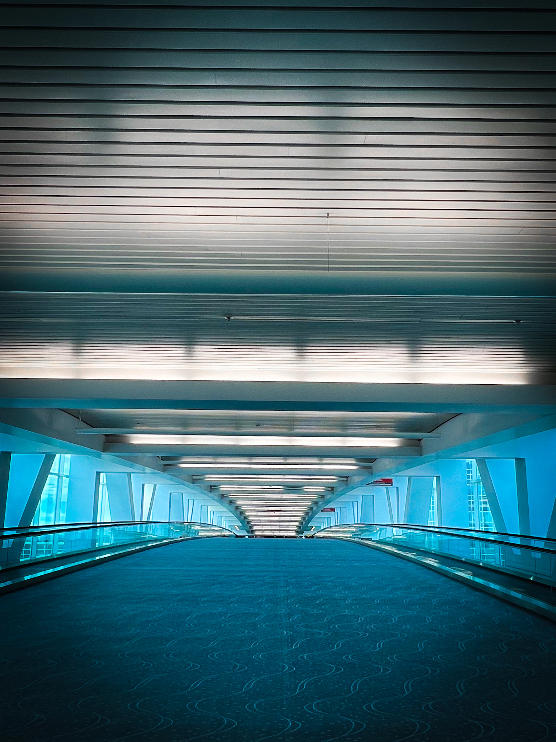 Elevator descends into a modern, blue-lit hallway.