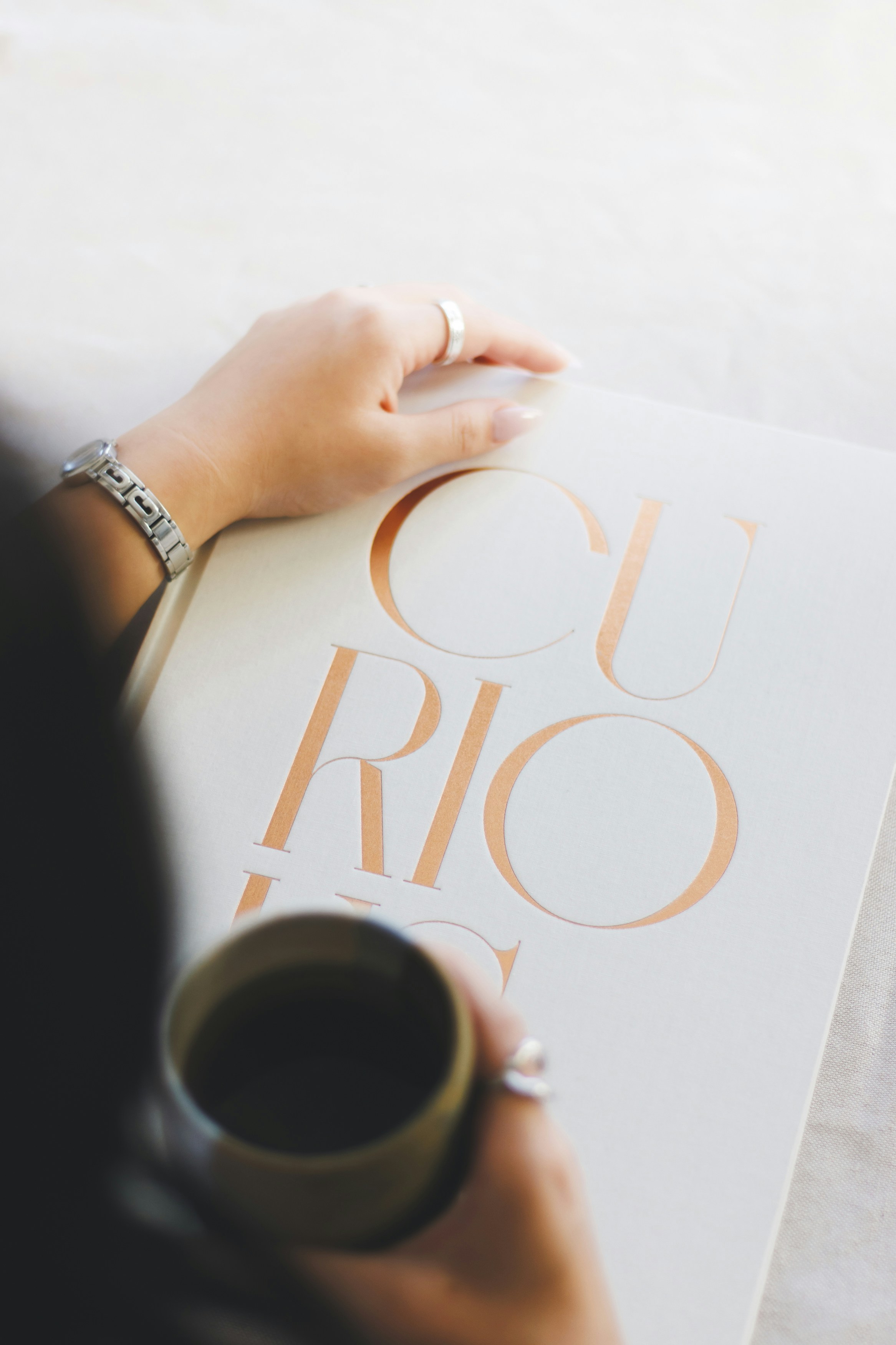 Someone is reading a book with a cup of coffee.