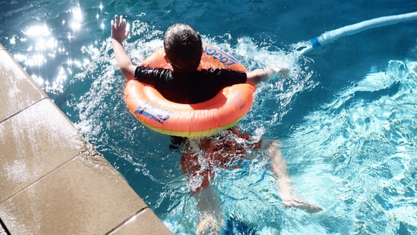 A child floats in a pool with an inflatable.