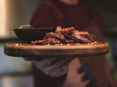 Grilled steak served on a wooden board, cooked over an open wood fire