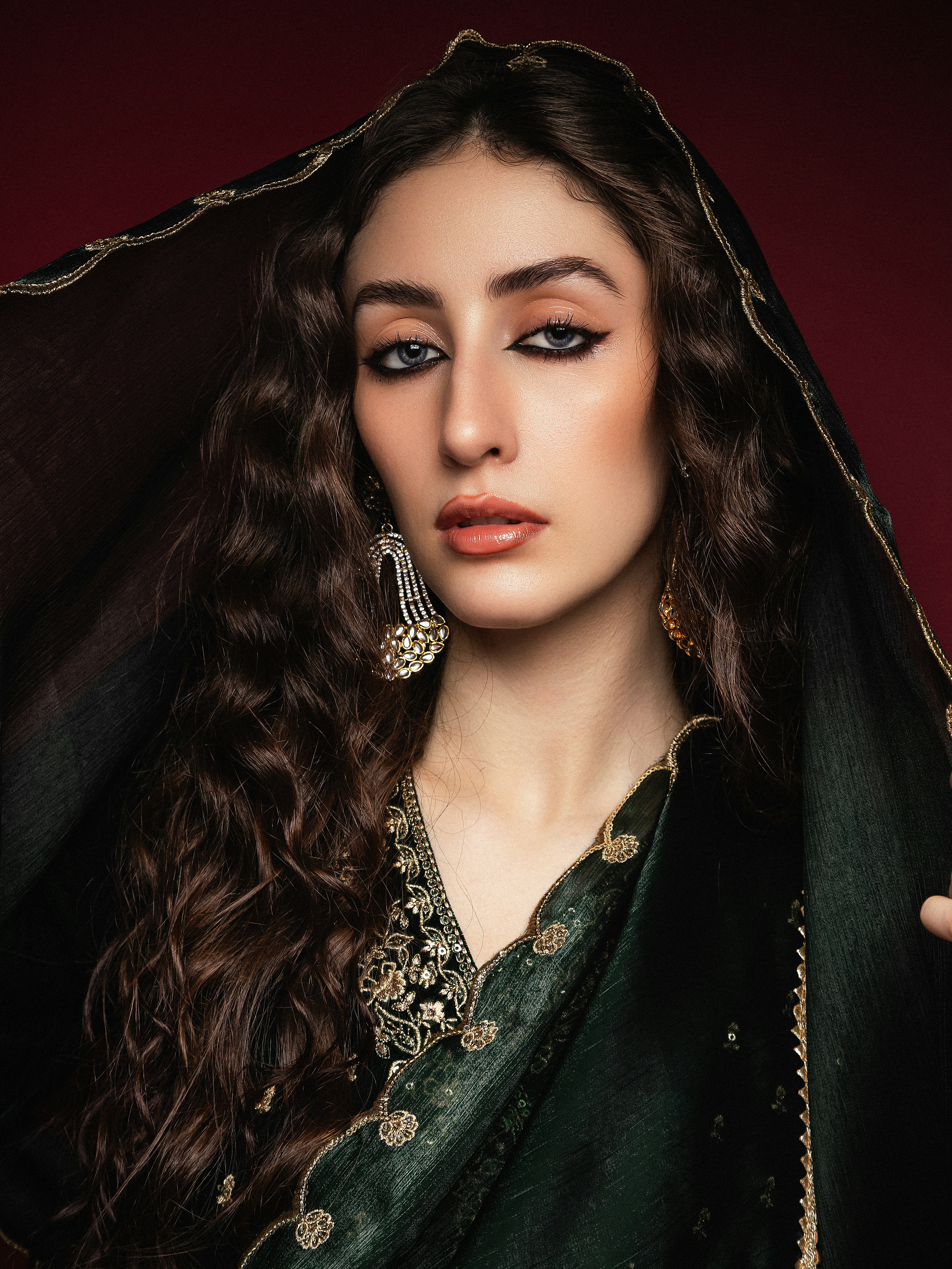 Elegante Frau in einem dunklen, verzierten Outfit.