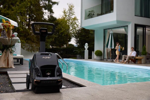 A robotic pool cleaner sits near the pool.