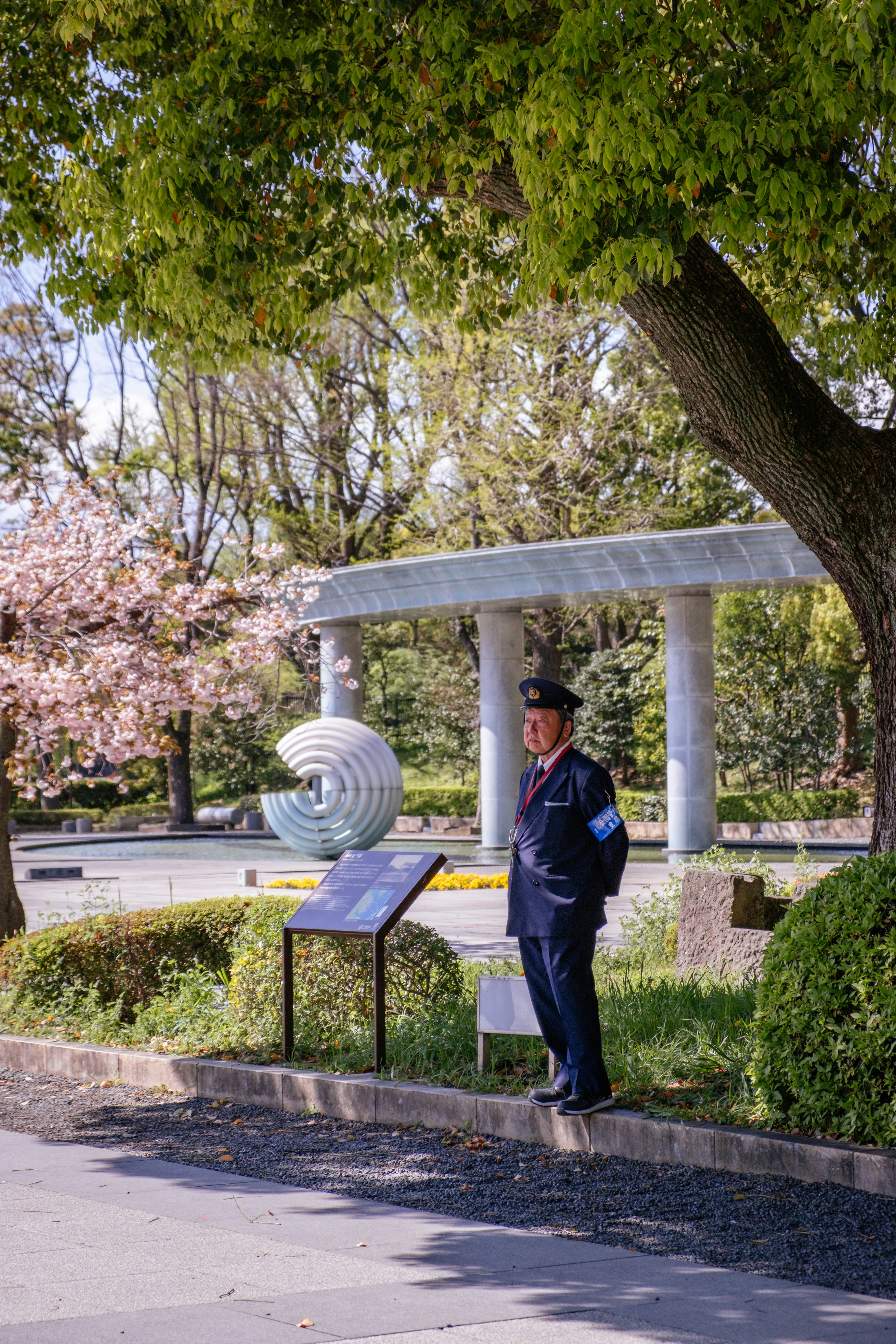 A uniformed man stands guard near a memorial.