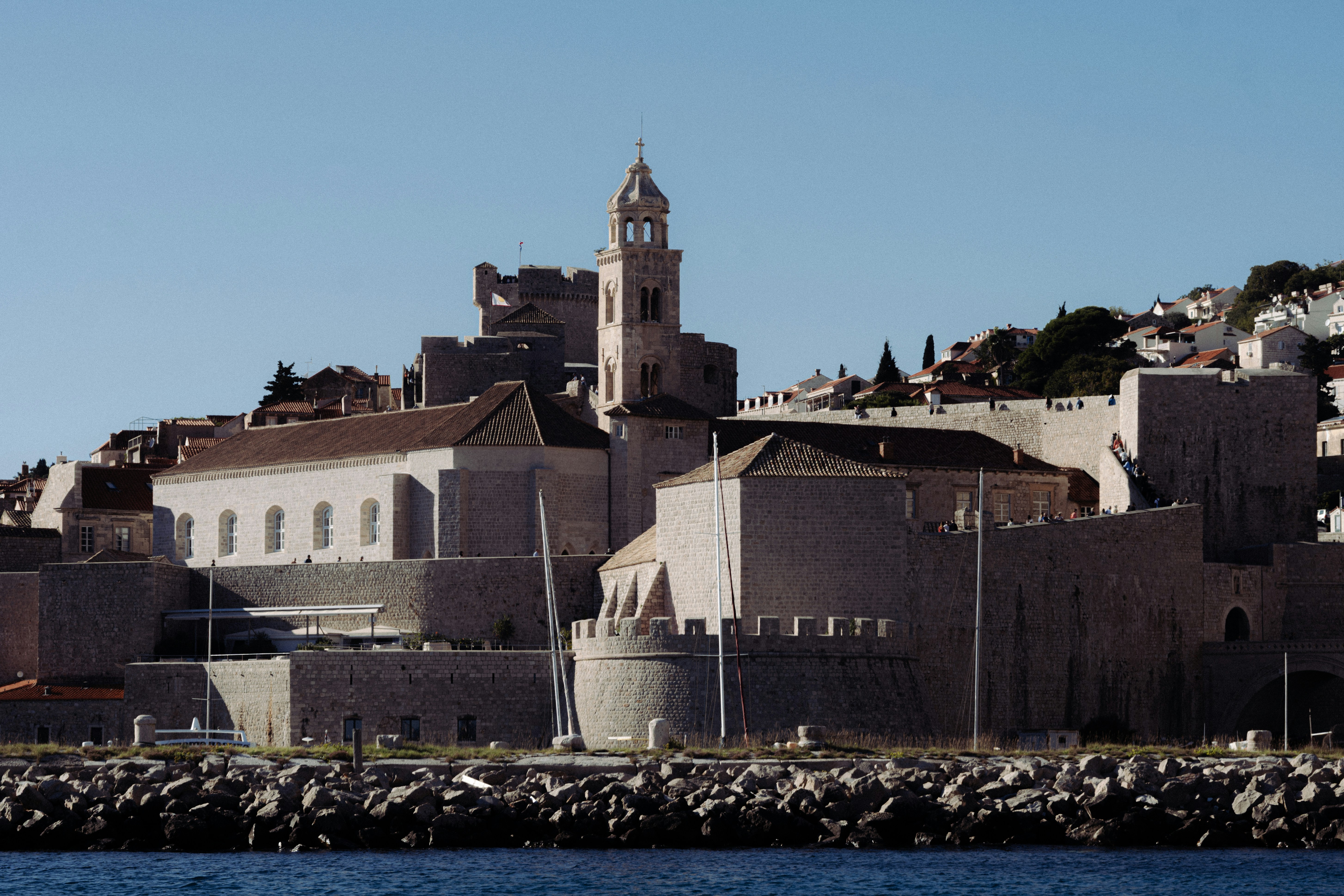 Historic city skyline with stone buildings and a tower.