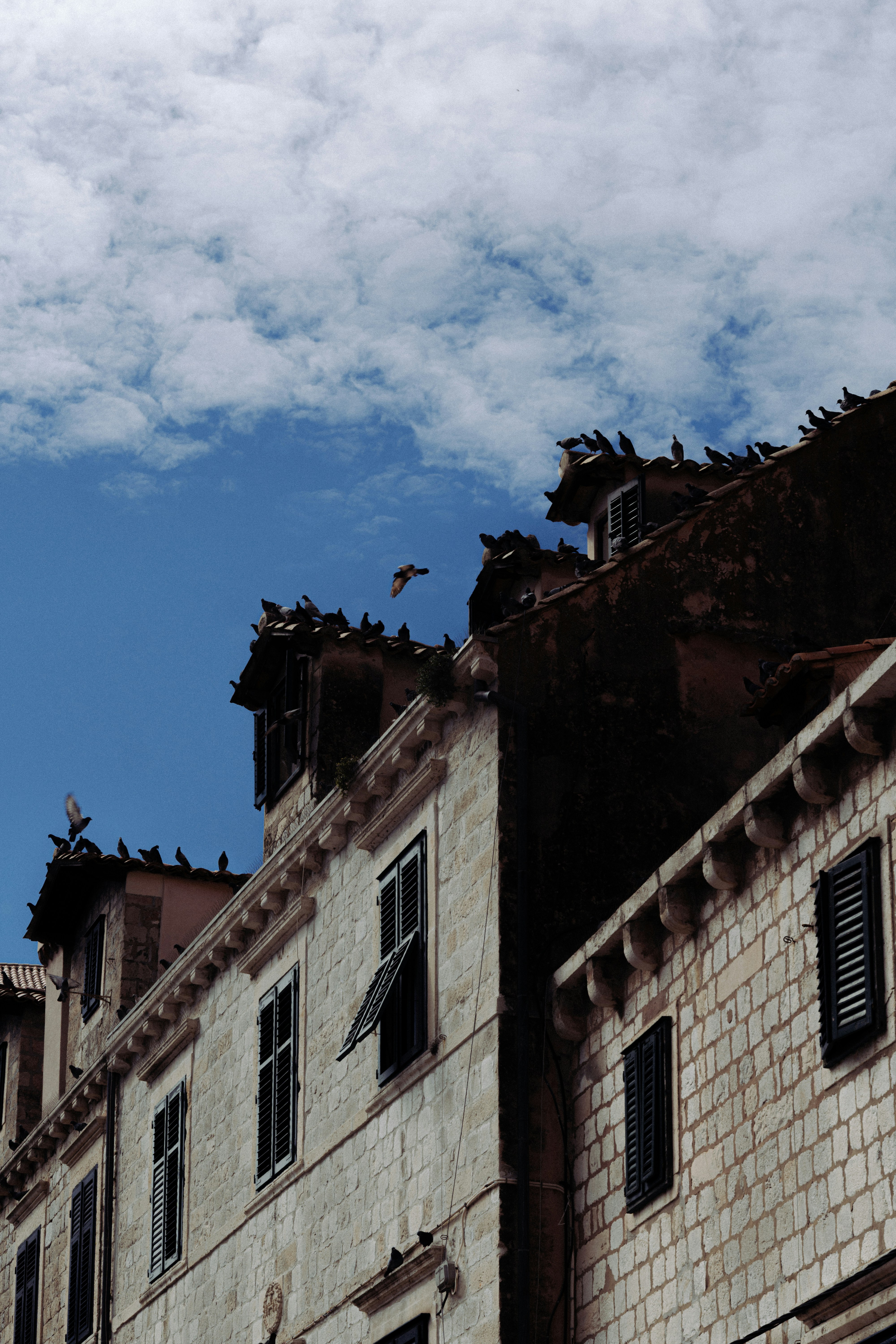 Stone buildings stand beneath a bright blue sky.