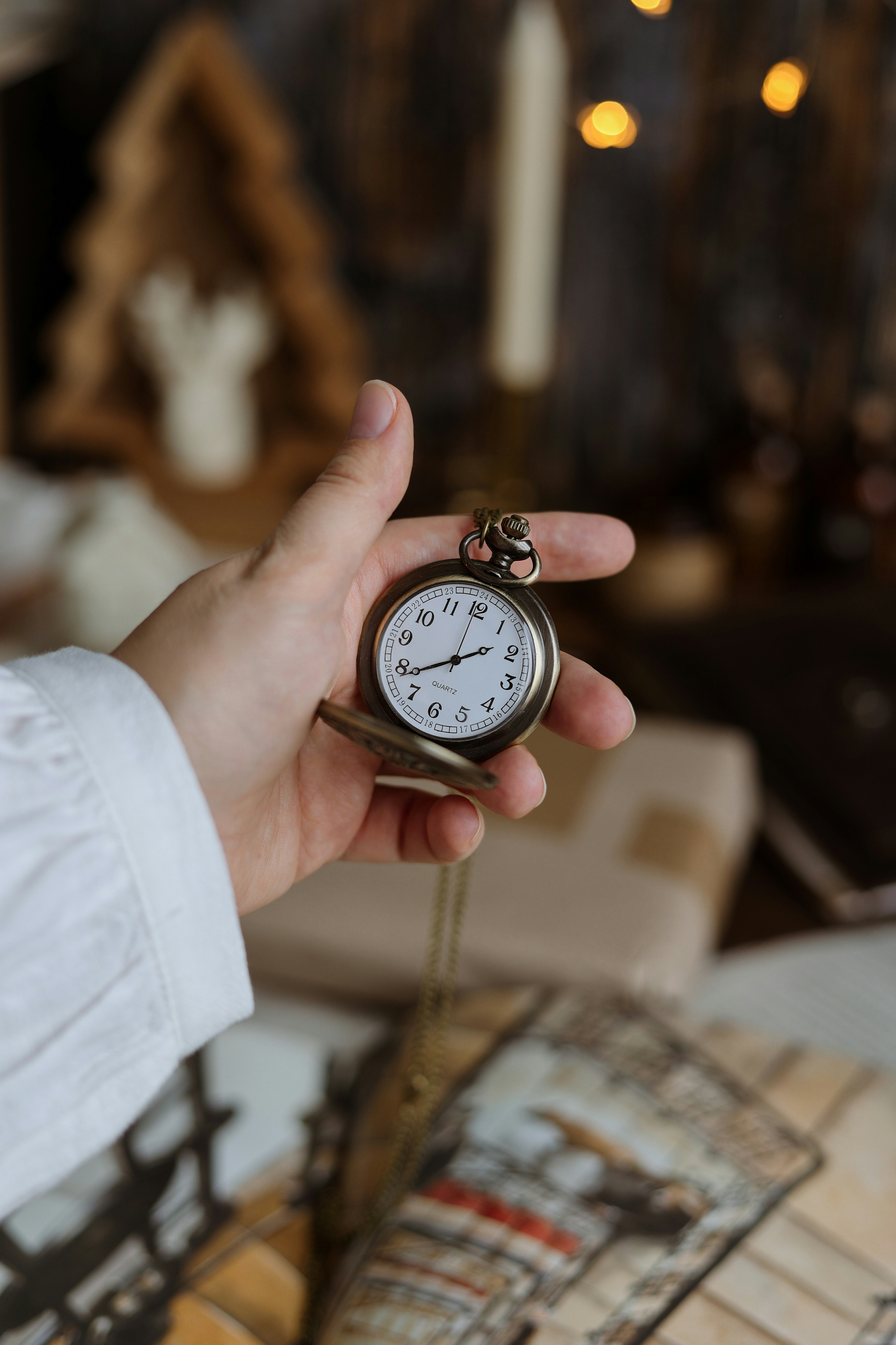 Hand holding an open pocket watch, vintage style.
